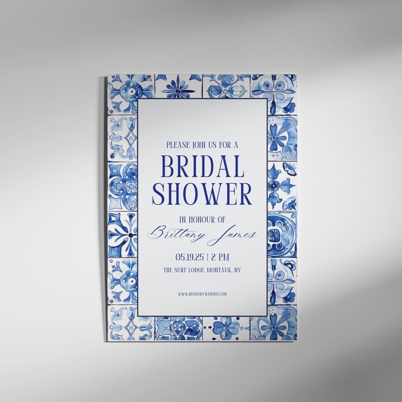 Elegant blue and white bridal shower invitation featuring a tile pattern border, displayed against a minimalist gray wall background.