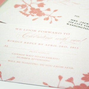 K&ouml;nnte beinhalten: Eine rosa und wei&szlig;e RSVP-Karte mit floralem Design. Der Text lautet "We look forward to celebrating with you!" und "Kindly reply by April 3rd, 2015".