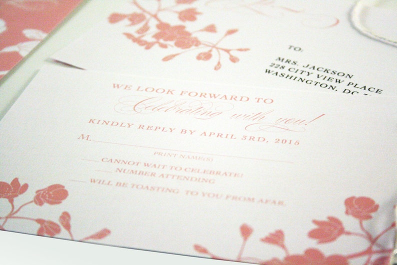K&ouml;nnte beinhalten: Eine rosa und wei&szlig;e RSVP-Karte mit floralem Design. Der Text lautet "We look forward to celebrating with you!" und "Kindly reply by April 3rd, 2015".
