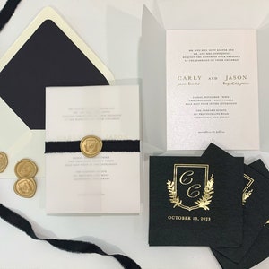 May include: Wedding invitation suite featuring black and white envelopes, a white card with gold lettering, and black napkins with gold foil lettering. The invitation reads "Carly and Jason" and the napkins read "October 13, 2023".