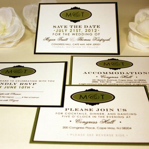 May include: Four ivory wedding invitation cards with black and green borders. The cards feature a monogram with the initials "M&T" in a green oval with a black border. The text on the cards includes the date "July 21st, 2012", the names "Megan Fruitt & Thomas Kasprzak", and the location "Congress Hall, Cape May, New Jersey".