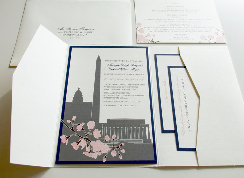 May include: A wedding invitation with a navy blue border and a grey silhouette of the Washington Monument and the Capitol Building. The invitation features a pink cherry blossom branch and the text "Together with our families, Morgan Leigh Ferguson and Richard Elliott Myers request the honour of your presence as we are married on Saturday, the sixteenth of April at five o'clock in the evening, two thousand and sixteen, The Mayflower Hotel, The Connecticut Avenue Northwest Washington, DC. Dinner and dancing to follow. Semi-formal cocktail attire."