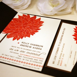 May include: A wedding invitation with a red floral design. The invitation reads "Kelly Shannon and Andrew Asbra invite you to celebrate our love as we are married Saturday, September 18th, Two Thousand and Ten at half past three in the afternoon."