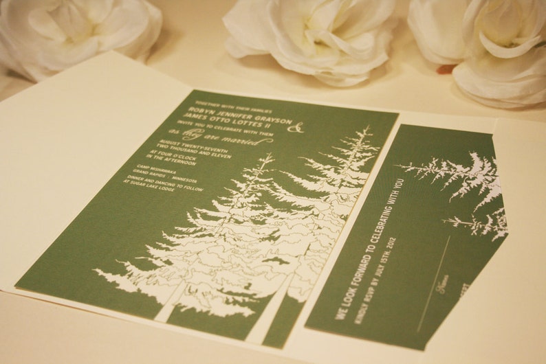 Op de afbeelding: Een groene huwelijksuitnodiging met witte tekst en een ontwerp van dennenbomen. De uitnodiging luidt "Robin Jennifer Grayson & James Otto Lottes II" en "We kijken ernaar uit om met u te vieren. Graag uw aanwezigheid bevestigen voor 15 juli 2012."