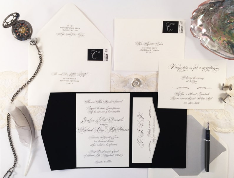 Puede incluir: Una invitaci&oacute;n de boda en blanco y negro con escritura caligr&aacute;fica. La invitaci&oacute;n est&aacute; doblada por la mitad y tiene un sobre negro. La invitaci&oacute;n incluye los nombres de la novia y el novio, la fecha y la hora de la boda, y la ubicaci&oacute;n de la ceremonia y la recepci&oacute;n.