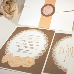 K&ouml;nnte beinhalten: Eine Hochzeitseinladung mit braunem Jutesack-Hintergrund und wei&szlig;em Spitzenbesatz. Die Einladung zeigt ein Pfirsichfarbenes Rosenmotiv und den Text "Gemeinsam mit ihren Familien, Lish Hinkle und Brent Alexander Dawson bitten um die Ehre Ihrer Anwesenheit bei ihrer Hochzeit, am siebzehnten Juli zweitausendvierzehn, um sechs Uhr abends, im Burke Museum of Natural History, 17 Ave und 43rd St, Seattle, Washington. Empfang im Anschluss im Lesesaal, Burke Museum of Natural History."