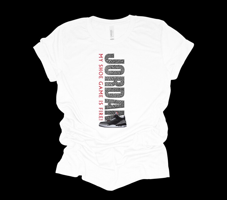Puede incluir: Camiseta blanca con un gr&aacute;fico rojo y negro de una zapatilla de baloncesto y el texto "JORDAN MY SHOE GAME IS FIRE!"