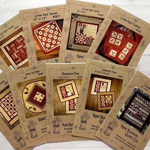 May include: A collection of eight quilt patterns featuring a red and white color scheme. The patterns are titled "Little Red Three", "Little Red Seven", "Little Red Nine", "Little Red Fourteen", "Little Red Twelve", "First of May", "Seasons One", and "Seasons Two".