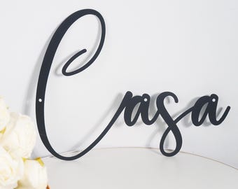 May include: Black metal wall decor with the word "Casa" in a cursive font.