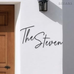 May include: A white wall with the text "The Steven" written in black cursive script.