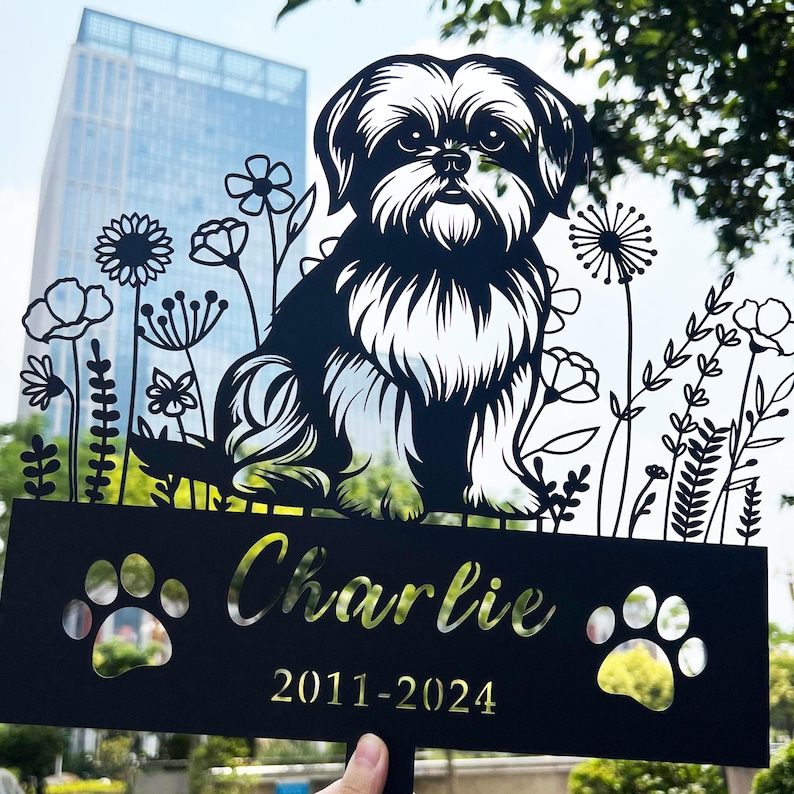May include: Black metal silhouette of a dog with flowers and the name Charlie and the dates 2011-2024.