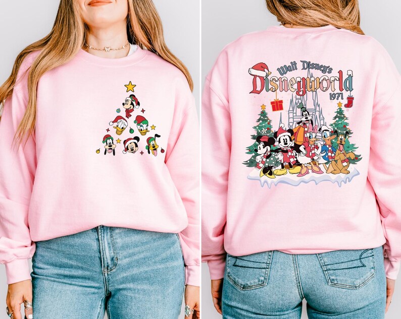 Pode incluir: Camisola cor-de-rosa com um design de &aacute;rvore de Natal com o Mickey Mouse e os seus amigos na frente e um design "Walt Disney's Disneyworld 1971" nas costas.