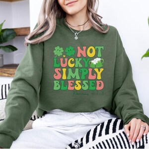 Puede incluir: Sudadera verde, amarilla, rosa y blanca con el texto "Not Lucky Simply Blessed Romans 4:1-8".