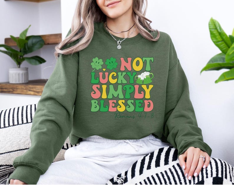 Puede incluir: Sudadera verde, amarilla, rosa y blanca con el texto "Not Lucky Simply Blessed Romans 4:1-8".
