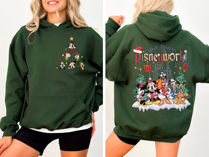 Pode incluir: Camisola de capuz verde com um design de &aacute;rvore de Natal com personagens da Disney na frente e um design "Walt Disney's Disneyworld 1971" com personagens da Disney nas costas.