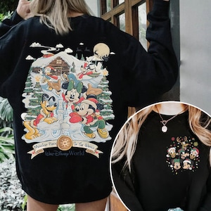 May include: Black sweatshirt with a Christmas-themed design featuring Mickey Mouse and friends in a snowy winter scene. The text on the sweatshirt reads "Happiest Place In The World (Walt Disney World)".