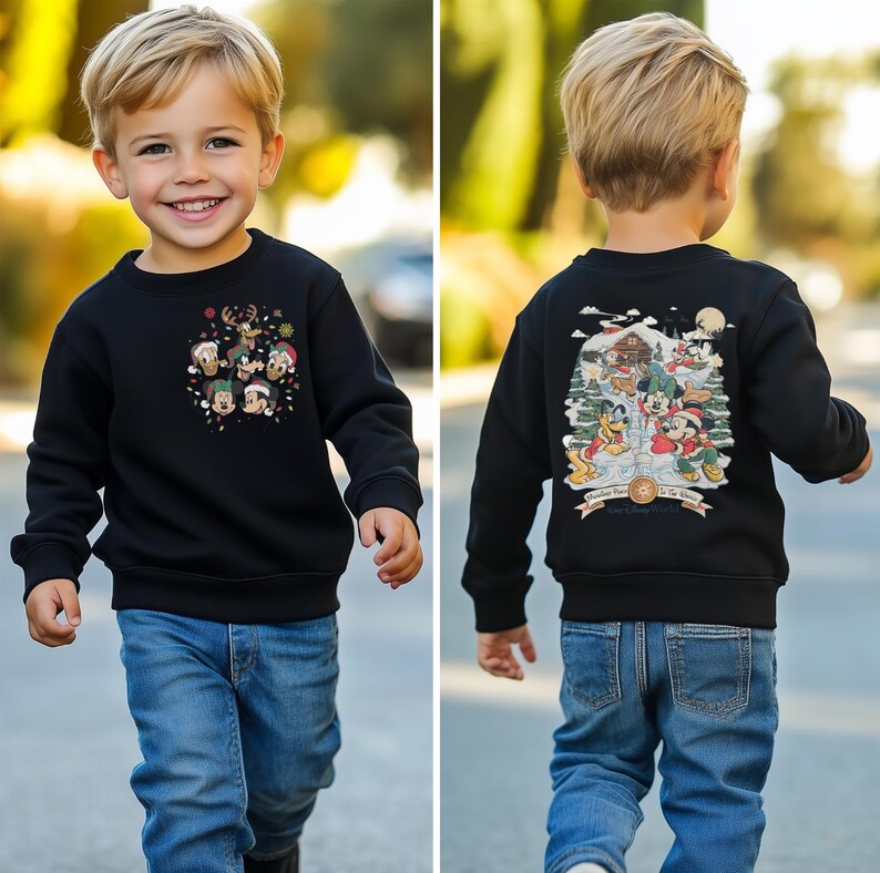 May include: A black sweatshirt with a Christmas-themed design featuring Mickey Mouse and friends. The front of the sweatshirt has a circular design with Mickey Mouse and friends wearing Santa hats. The back of the sweatshirt has a scene of Mickey Mouse and friends celebrating Christmas in a snowy village.
