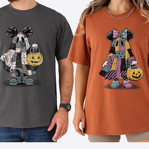 Peut inclure: Deux t-shirts à manches courtes, un gris poivre et un orange igname, chacun avec un personnage de dessin animé vêtu d'un costume patchwork et tenant une lanterne citrouille. Le personnage a des oreilles de souris et porte des chaussures. Vêtements décontractés.