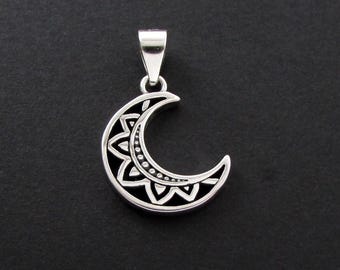 May include: Silver-toned crescent moon pendant with intricate floral and geometric patterns. The pendant features a detailed design with a dark background, and a loop for a chain. The celestial-themed jewelry is suitable for everyday wear.