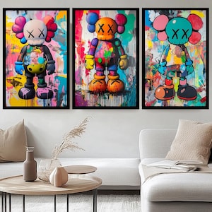 Op de afbeelding: Drie kleurrijke abstracte schilderijen met cartoonfiguren met de tekst "XX" op hun gezichten. De figuren staan op een kleurrijke achtergrond met verfspatten.