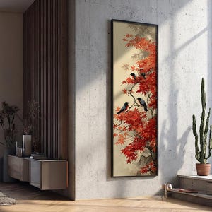 May include: A framed vertical art print featuring a vibrant red maple tree with black birds perched on its branches. The artwork has a beige background and is set against a concrete wall, adding a touch of nature-inspired decor.