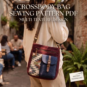 May include: A crossbody bag featuring a deep burgundy main body, a patterned fabric panel with geometric shapes, and a solid navy blue pocket with a brown leather-like strap and buckle. Text reads: CROSSBODY BAG SEWING PATTERN PDF MULTI-TEXTURE DESIGN.