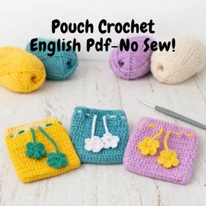 Op de afbeelding: Gehaakte zakjes in geel, turquoise en lavendel, elk met een uniek bloemmotief. De afbeelding toont ook bollen wol in verschillende kleuren en een haaknaald. De tekst op de afbeelding luidt "Pouch Crochet English Pdf-No Sew!"