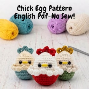 May include: Three crocheted chick egg figures with black eyes and yellow beaks, each with a different colored base and headpiece. The text "Chick Egg Pattern English Pdf-No Sew!" is at the top. Yarn balls in yellow, teal, purple, and cream are in the background.