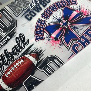 May include: A white fabric sheet featuring a repeating pattern of football-themed graphics, including brown footballs, blue and pink bows, and text that reads Let's Go COWBOYS, FATE COWBOYS, and football. The design includes black and white accents.