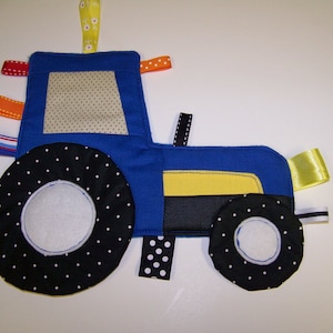 May include: Blue and yellow fabric tractor toy with black and white polka dot wheels and colourful ribbon accents.