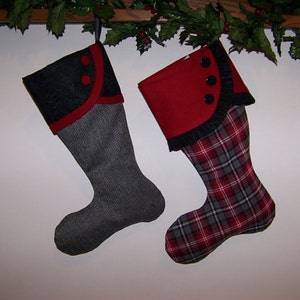 Może przedstawiać: Dwie świąteczne skarpety z czerwoną i czarną lamówką. Jedna skarpeta jest szara w kratę, a druga czarna w kratę.
