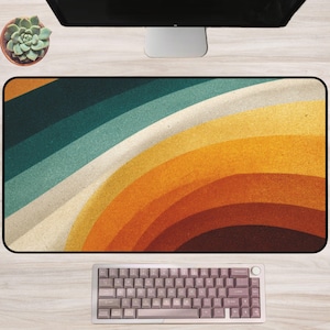May include: A rectangular desk mat with a retro-inspired design featuring curved stripes in shades of teal, light blue, cream, yellow, orange, and brown. A mechanical keyboard is at the bottom. A succulent plant in a brown pot is at the top left.
