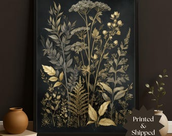 May include: A framed botanical print featuring a detailed illustration of various plants in shades of gold, gray, and green against a dark background. The artwork includes ferns, leaves, and flowering plants. The text "Printed & Shipped" is visible.