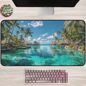 May include: A large rectangular desk mat featuring a tropical beach scene with turquoise water, palm trees, and overwater bungalows. A mauve keyboard sits below the mat. A succulent plant in a brown pot is visible.