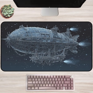 May include: A rectangular mouse mat with a detailed illustration of a steampunk airship against a starry night sky. The airship is blue and grey, with intricate mechanical details. A keyboard is at the bottom.