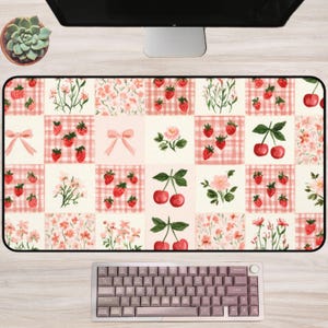 Könnte beinhalten: Eine rechteckige Schreibtischunterlage mit einem Gittermuster aus abwechselnden Quadraten mit rosa Vichy-Karo, Blumenillustrationen, Erdbeeren, Kirschen und Schleifen. Das Design zeigt zarte Rosa-, Rot- und Grüntöne auf cremefarbenem Grund.