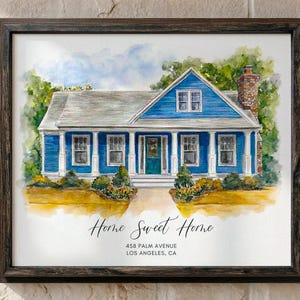 May include: Watercolor painting of a blue house with white trim, a gray roof, and a brick chimney. The painting is framed in a dark wood frame. The words "Home Sweet Home" are written in cursive below the house, along with the address.