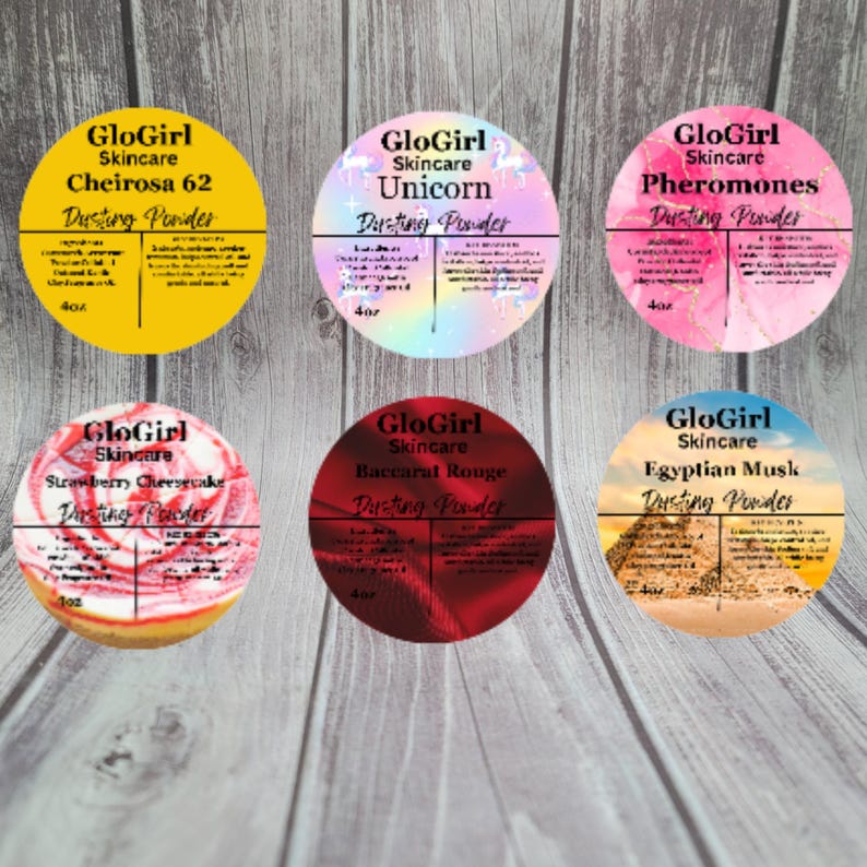 May include: Six round containers of GloGirl Skincare dusting powder are displayed. The containers feature various designs and scents, including Cheirosa 62, Unicorn, Pheromones, Strawberry Cheesecake, Baccarat Rouge, and Egyptian Musk. Each container is labeled with the product name and brand.