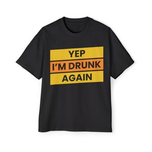 Könnte beinhalten: Schwarzes T-Shirt mit einer gelben und orangenen Grafik, auf der "Yep I'm Drunk Again" steht.