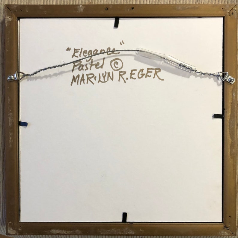 Op de afbeelding: De achterkant van een ingelijst pasteltekening met de titel "Elegance" van kunstenaar Marilyn R. Eger.