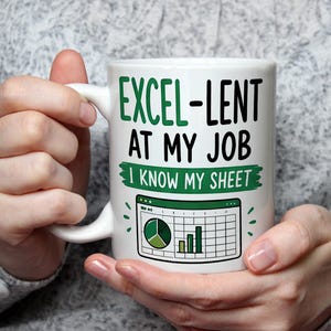 Könnte beinhalten: Ein weißer Keramikbecher mit dem grünen und schwarzen Text EXCEL-LENT AT MY JOB und I KNOW MY SHEET. Unter dem Text befindet sich eine grafische Darstellung eines Tabellenkalkulationsfensters mit einem grünen Kreisdiagramm und einem Balkendiagramm.