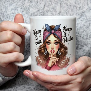 May include: White ceramic mug featuring a colourful illustration of a woman with a pink bandana and a finger to her lips. The text "Keep it cute" and "Keep it Mute" is printed on the mug.