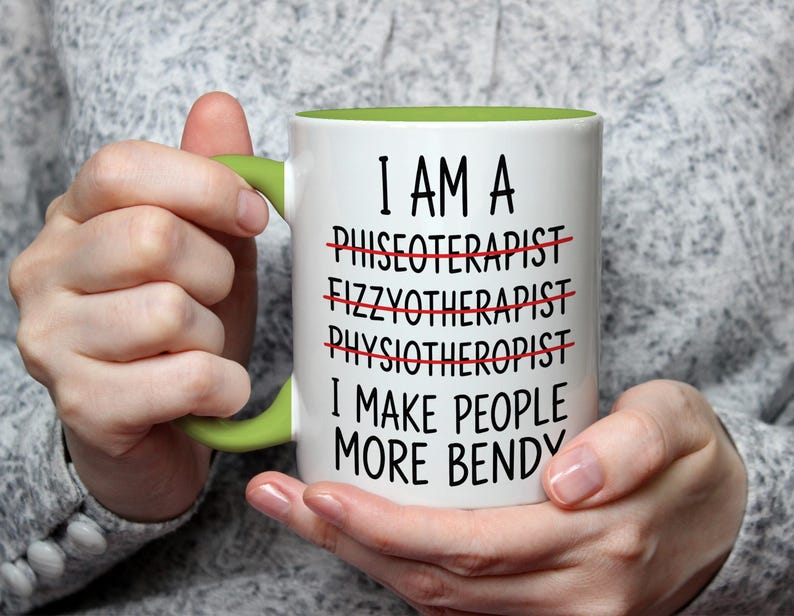 May include: White ceramic mug with a green handle and interior. The mug features the text "I AM A... I MAKE PEOPLE MORE BENDY" with crossed-out words. A humorous gift for a physical therapist.