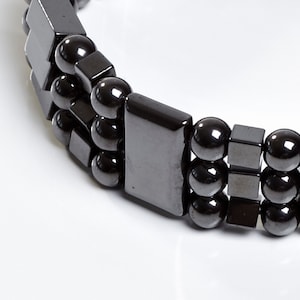 Könnte beinhalten: Ein schwarzes Armband aus runden und rechteckigen Perlen. Das Armband ist aus Hämatit.