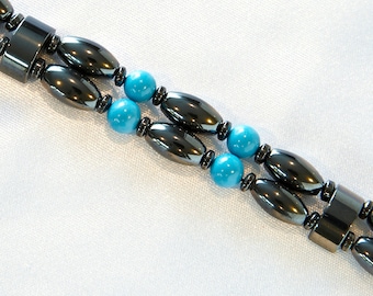 May include: A double-strand bracelet with black oval-shaped magnetic beads and turquoise round beads.