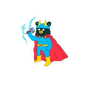 Puede incluir: Una pegatina con un oso de dibujos animados disfrazado de superhéroe. El oso lleva un traje azul, botas amarillas y una capa roja. Sostiene un martillo y está rodeado de rayos azules. El oso tiene una cara negra y un cinturón amarillo.