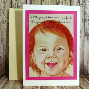 May include: A pink card with a white border and a drawing of a smiling child with red hair. The card has a quote from the Bible, "Let the young children come to me, for the Kingdom of God belongs to such ones." Luke 18:16