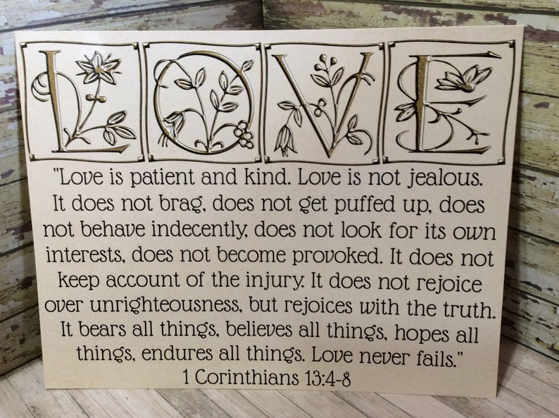 May include: A beige card with the word "LOVE" in gold lettering with floral designs. The card features a quote from 1 Corinthians 13:4-8 about the characteristics of love.