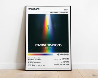 Puede incluir: Un póster enmarcado del álbum "Evolve" de Imagine Dragons de 2017. La obra de arte muestra a una persona en un haz de luz de arcoíris sobre un fondo oscuro. El póster incluye el título del álbum, el nombre de la banda y una lista de canciones.