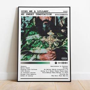 Puede incluir: Un póster en blanco y negro con una imagen verde y negra de una persona con una corona y sosteniendo una cruz. El póster tiene el texto "SING ME A LULLABY, MY SWEET TEMPTATION $UICIDEBOY$ 2022" en la parte superior. El póster también enumera los nombres de las canciones del álbum.